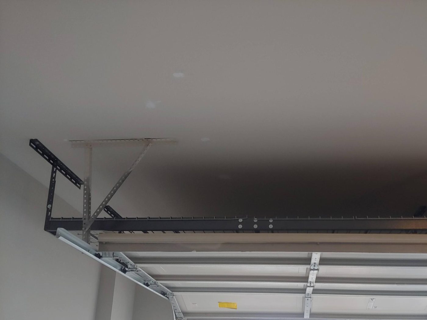 Close-up of an overhead storage rack mounted just above the garage door track