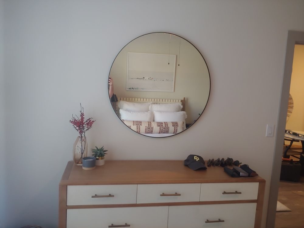 Round mirror hung over a dresser
