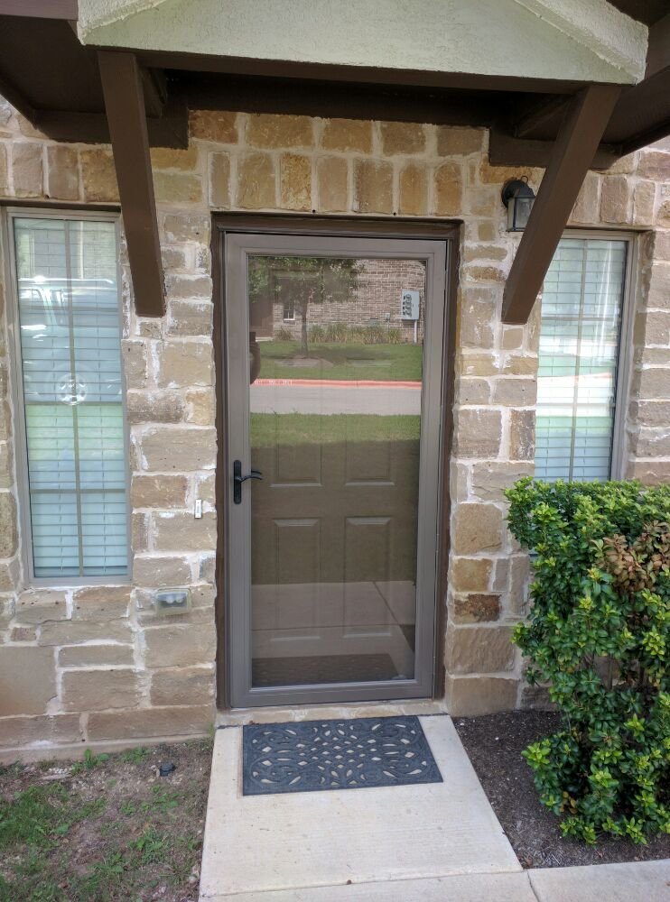 Glass storm door installed at a stone entry